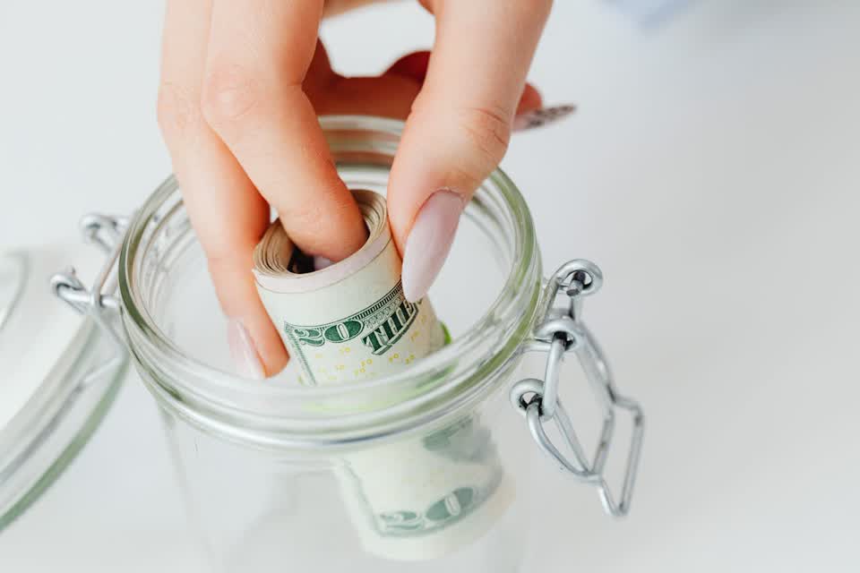 Person holding rolled bank notes